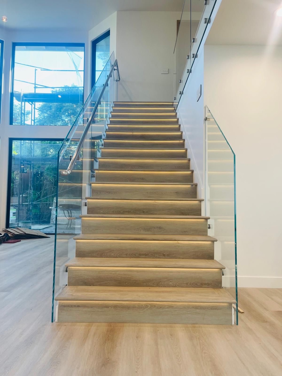 Front view of illuminated staircase with glass railings during final finishing